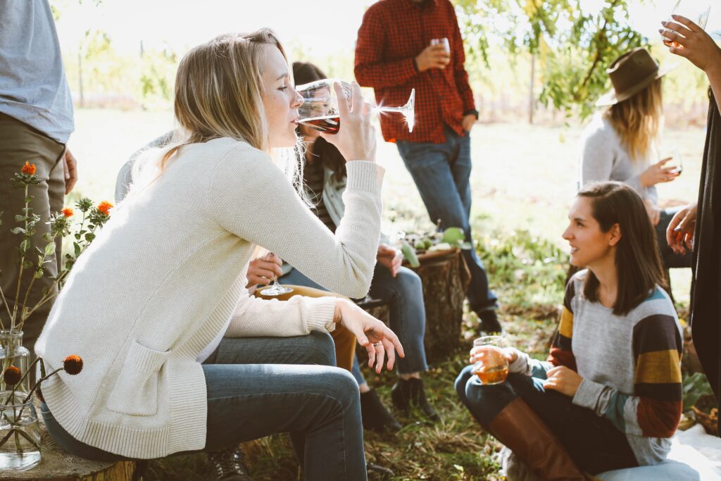 girl drinking red wine outside with friends