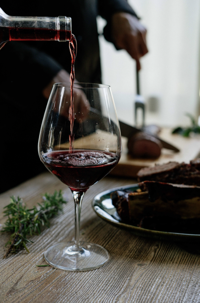 pouring glass of Pinot Noir to pair with food